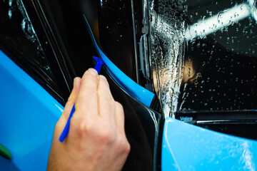 Micro Squeegee on Trim Wrap. Micro squeegee tool ensures seamless adhesion during car wrap...