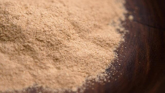 Ayurvedic Ashwagandha root powder in wooden bowl. Calming anti-stress supplement. Rotation