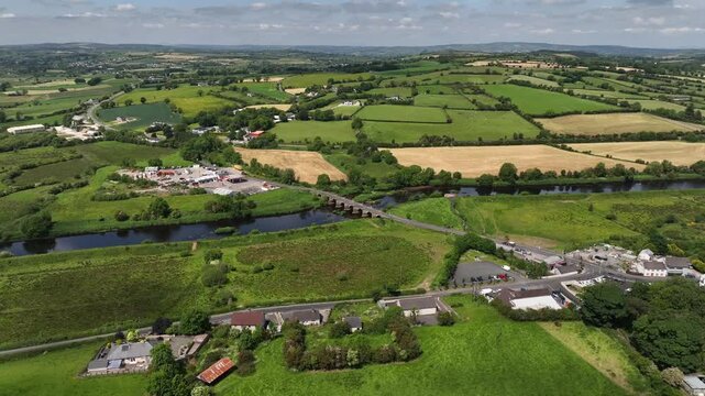 Clady Bridge, County Tyrone, Northern Ireland, June 2023. Drone panoramic orbit clockwise above River Finn showcasing arched bridge connecting towns.
