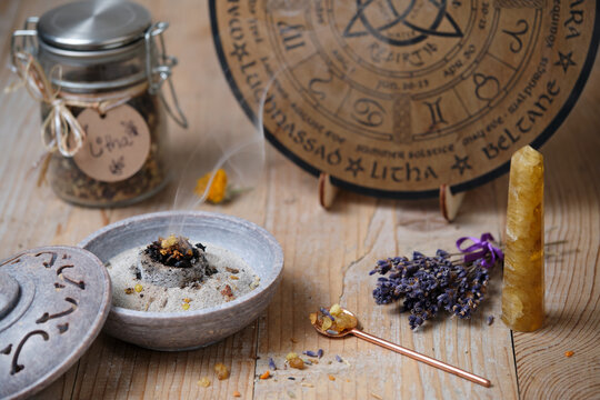 Incense ritual with frankincense, resins and dried herbs at Litha festival in warm sunlight