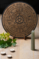 Wooden Wheel of the Year engraved with the eight pagan festivals on a wooden table. Spiritual and...