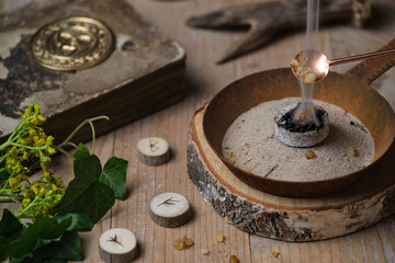 Incense ritual at wheel of the year festival Samhain with frankincense, myrrh and dried herbs in...