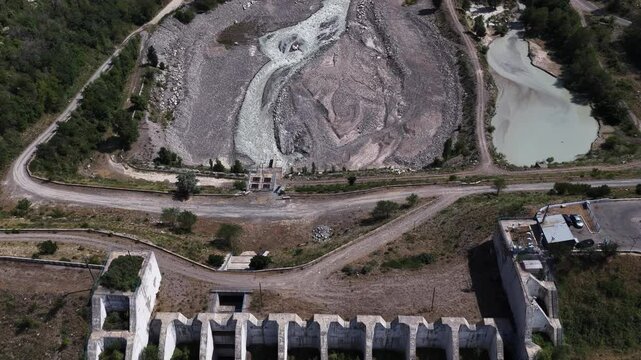 A protective dam against mudflows. Talgar gorge, Tian Shan Mountains. Different vegetation and a mountain river. The view from the drone.