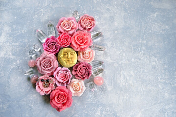 moon amulet, crystals and artificial pink red rose flowers on abstract light grey background. Magic, esoteric spiritual ritual with gemstones and moon symbol. witchcraft. Love, romantic vibes. 
