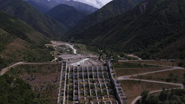 A protective dam against mudflows. Talgar gorge, Tian Shan Mountains. Different vegetation and a mountain river. The view from the drone.