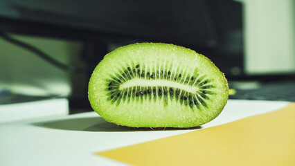Fresh kiwi fruit halves and whole with seeds and green flesh close up macro