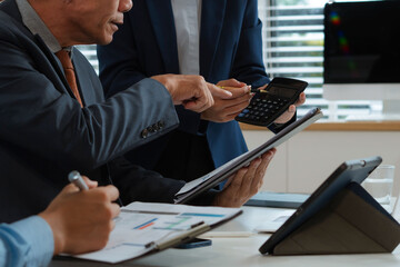 Professional business team meeting with consultant and project planning charts.