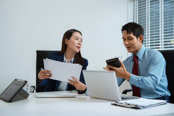 Business team analyzing documents, graphs, and data with a laptop, tablet, and smartphone. Collaboration, strategy, and success.