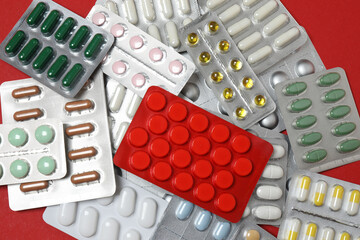 blisters with pills, pills, on a red background