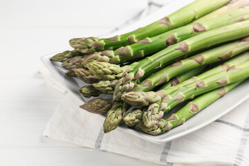 Fresh raw asparagus spears on white wooden table, closeup