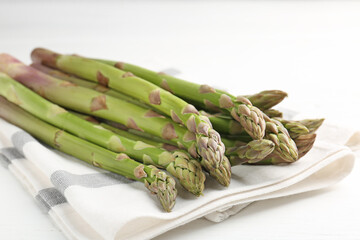 Fresh raw asparagus spears on white wooden table, closeup