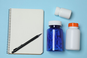 blisters of tablets, tablets, prescription notebook with space for text on a blue background