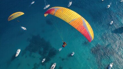 Tandem paragliders soaring over the blue sea, two people in one sailglider on a high wing with yellow and red colors