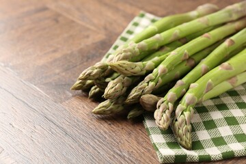 Fresh raw asparagus on wooden table, closeup. Space for text