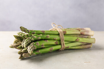 Fresh raw asparagus on light grey table, closeup
