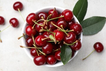 Wet ripe cherries on light table, flat lay