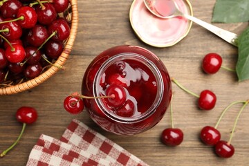 Tasty cherry jam and fresh fruits on wooden table, flat lay