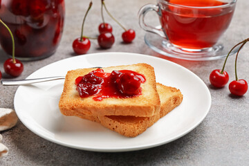 Toasts with tasty cherry jam, tea and fresh fruits on grey table , closeup