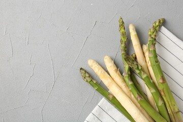Different raw asparagus spears on grey table, top view. Space for text