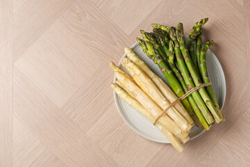 Different raw asparagus spears on wooden table, top view. Space for text