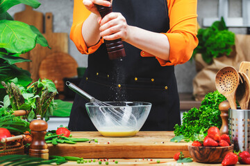 skilled chef grinds pepper in mill prepares healthy dish using fresh eggs and utensils in a bright...