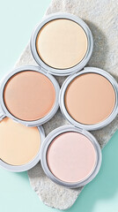 Fototapeta premium Five makeup powders in round compacts are arranged on a textured surface. Beauty products, makeup, variety, cosmetics