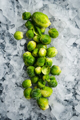 Frozen Brussels sprouts in a plastic bag. Frozen vegetable stock for the winter. On a gray concrete background.