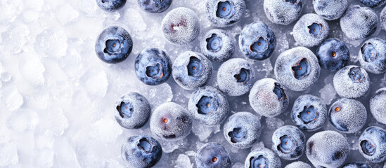 Blueberries are scattered on frozen ice, creating a fresh and frosty appearance. Concept: freshness, cold, natural, fruit
