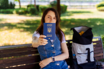 Young Woman Holding Ukrainian Passport in Park