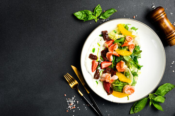 A colorful salad of shrimp, arugula and sun-dried tomatoes. Italian cuisine. Top view.