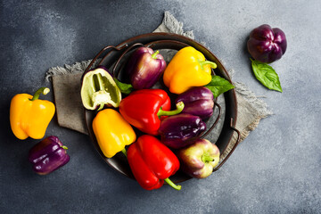 Red, purple and yellow bell peppers. Paprika on a metal tray. Free space for text.