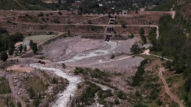 A protective dam against mudflows. Talgar gorge, Tian Shan Mountains. Different vegetation and a mountain river. The view from the drone.