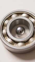 Close-up of a shiny metallic ball bearing, showcasing its intricate design and precision engineering, reflecting light with its smooth surface creating a captivating visual .