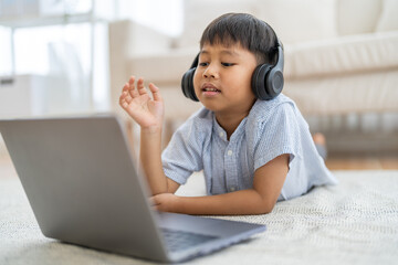Asian boy using laptop with headphones course online learning, distance education for kids,...