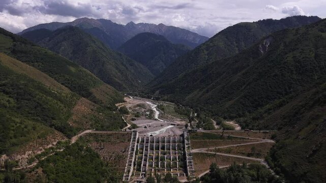 A protective dam against mudflows. Talgar gorge, Tian Shan Mountains. Different vegetation and a mountain river. The view from the drone.