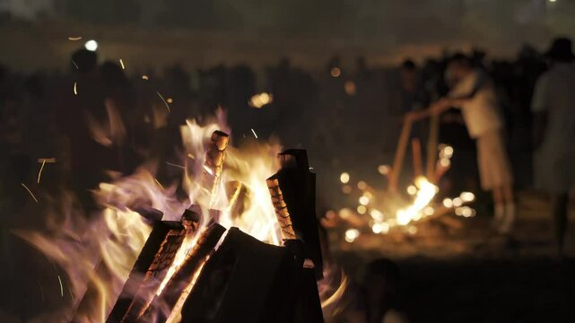 bonfires at st. John night fest in Coruna , Spain , with people unfocused and controlled fire on beach at night , 4k video footage