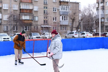 People skate and play ice hockey in the yard