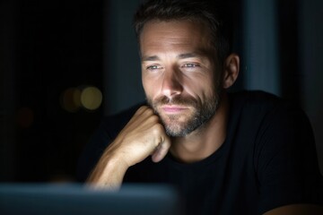 Fototapeta premium Caucasian adult male reflecting thoughtfully at night with soft lighting.
