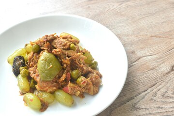 spicy fried roasted duck meat with grape and eggplant in curry on plate