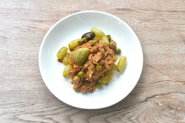 spicy fried roasted duck meat with grape and eggplant in curry on plate