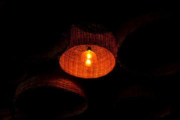 reddish colored lamp lit inside a wooden basket. decoration