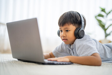 Asian boy using laptop with headphones course online learning, distance education for kids,...