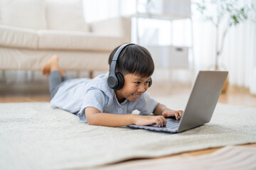 Asian boy using laptop with headphones course online learning, distance education for kids,...
