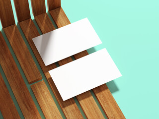 Two white business cards placed on a wooden surface with soft shadow play.