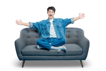 An excited young man sits on a sofa with his arms open wide in a joyful and welcoming gesture.PNG