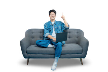 Asian man sitting on a sofa with a laptop raises a finger, as if having a good idea while working...