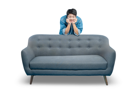 A young man with a cute, winking expression rests his chin on his hands while peeking over an empty sofa.PNG