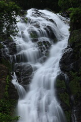 Fototapeta premium Namtok Sarika is the most famous waterfall in Nakhon Nayok , The nine-tiered waterfall cascading down the cliff to a forested hillside has a large natural pool on each level . THAILAND 