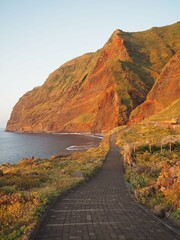 Valley of the remote village Achadas da Cruz under steep red cliffs at sunset, Madeira, Portugal