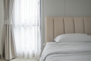 Bedroom scene with soft sunlight filtering through sheer curtains. Modern minimalism style bedroom...